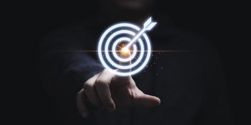 Businessman hand touching to target dart board for setup and achievement objectives target for business investment concept.