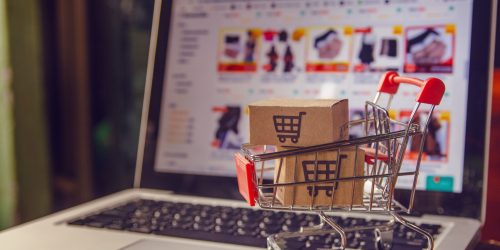 Shopping online concept - Parcel or Paper cartons with a shopping cart logo in a trolley on a laptop keyboard. Shopping service on The online web. offers home delivery.